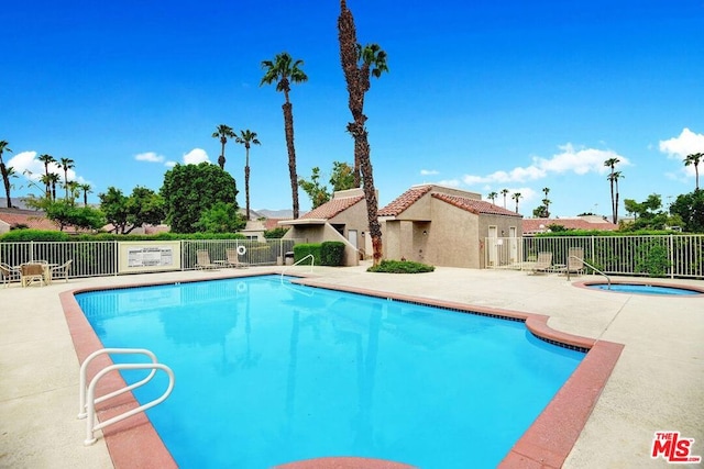 view of swimming pool with a patio area and a hot tub