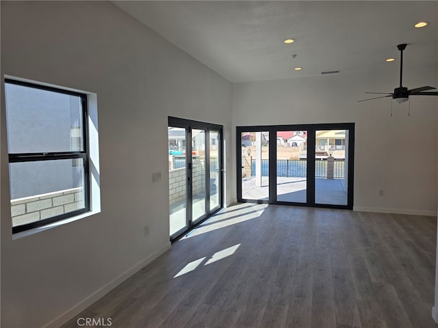 unfurnished room featuring dark hardwood / wood-style floors, french doors, ceiling fan, and a high ceiling