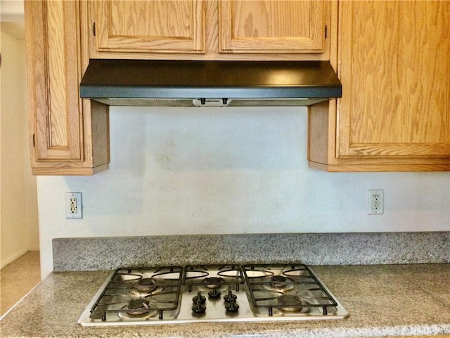 interior details featuring light countertops, stainless steel gas cooktop, and under cabinet range hood