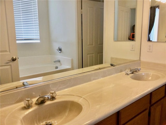 full bath featuring double vanity, a sink, and a bath