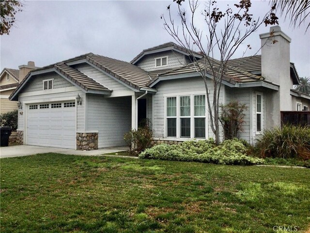 view of front of house with a garage and a front lawn