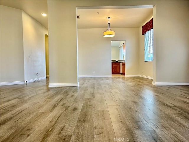 unfurnished dining area with baseboards and wood finished floors