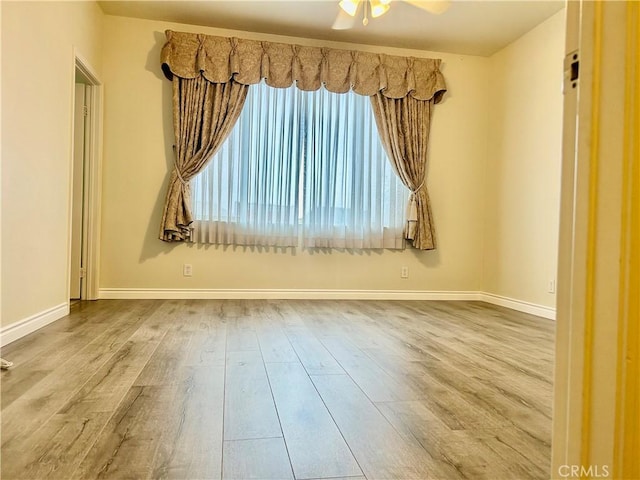 unfurnished room with ceiling fan, baseboards, and wood finished floors