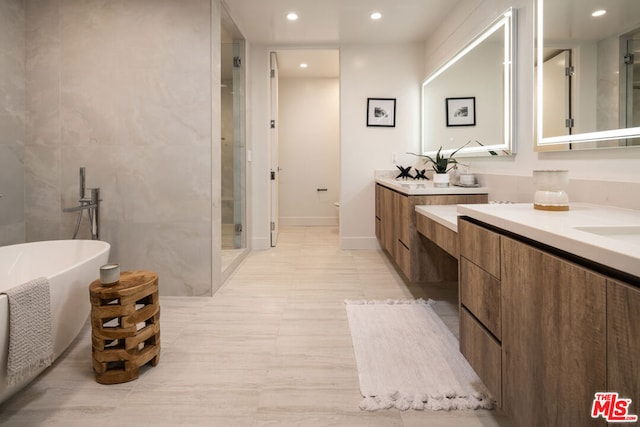 bathroom with vanity, shower with separate bathtub, and tile walls