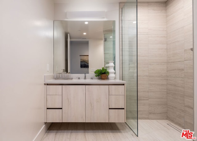 bathroom featuring vanity and tiled shower