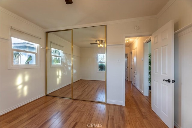 unfurnished bedroom with ornamental molding, a closet, and light wood-type flooring