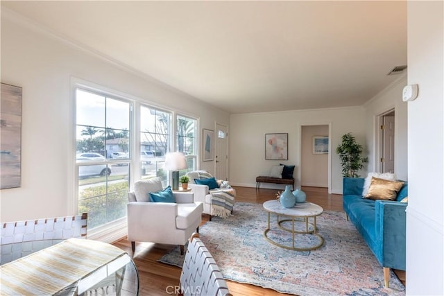 living room featuring hardwood / wood-style flooring and ornamental molding