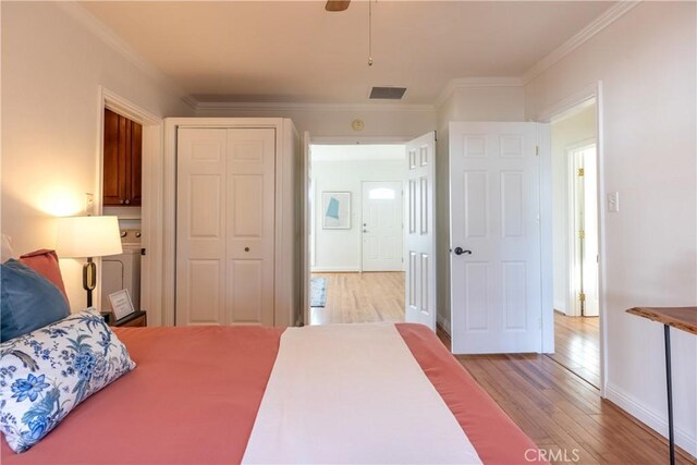 bedroom with ornamental molding, a closet, and light hardwood / wood-style flooring