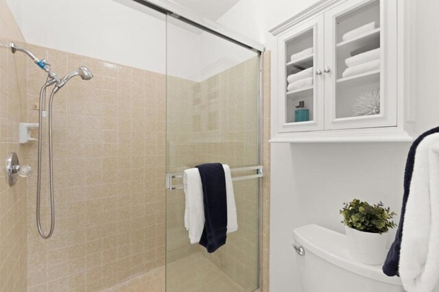 bathroom featuring toilet and an enclosed shower