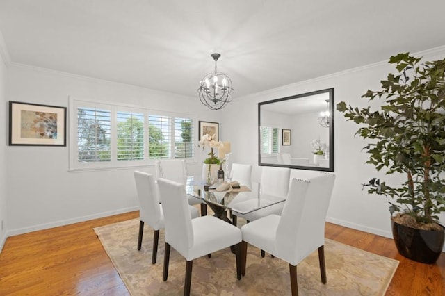 dining room featuring ornamental molding, a chandelier, and light wood-type flooring