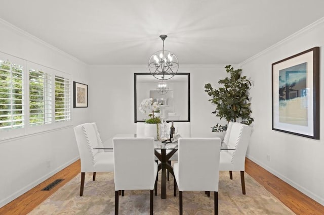 dining space with an inviting chandelier, wood-type flooring, and crown molding