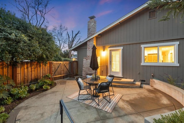 back house at dusk with a patio