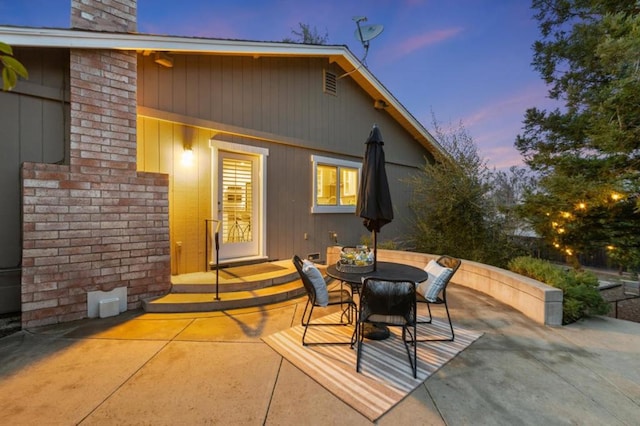 back house at dusk with a patio area