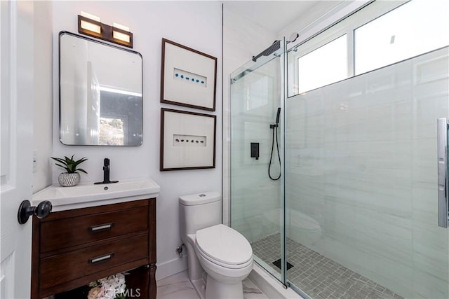 bathroom featuring vanity, toilet, and a shower with shower door