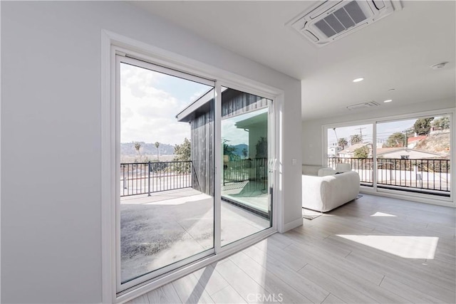 doorway featuring a wealth of natural light and light hardwood / wood-style flooring