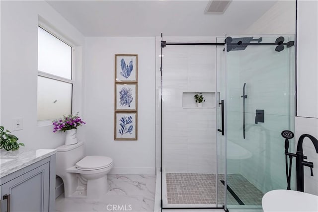 bathroom featuring vanity, a shower with shower door, and toilet