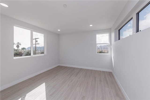 unfurnished room with a healthy amount of sunlight and light wood-type flooring