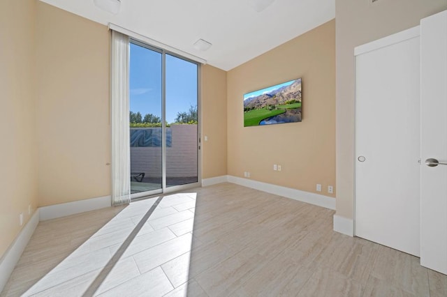 unfurnished room featuring expansive windows and light hardwood / wood-style flooring