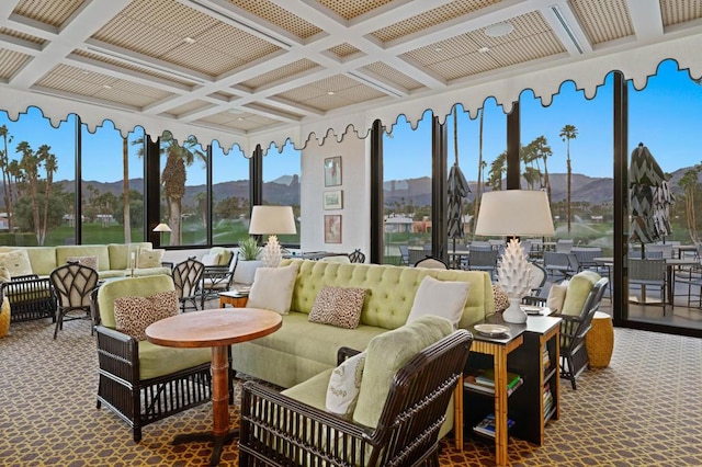 sunroom featuring beamed ceiling, plenty of natural light, coffered ceiling, and a mountain view