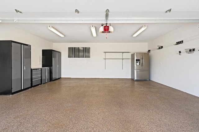 garage featuring a garage door opener and stainless steel fridge with ice dispenser