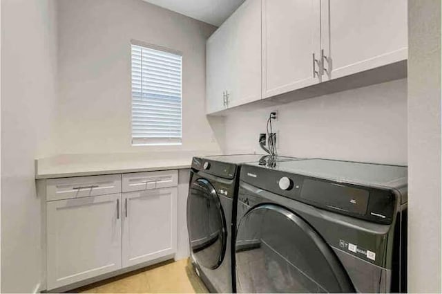 laundry area featuring cabinets, light tile patterned flooring, and separate washer and dryer