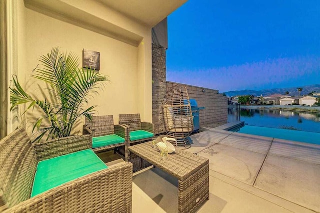 view of patio / terrace with an outdoor living space and a water view