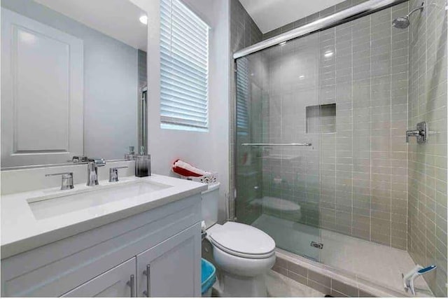 bathroom with vanity, toilet, and walk in shower