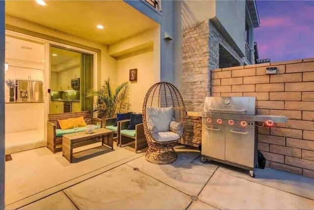 patio terrace at dusk featuring a grill and outdoor lounge area