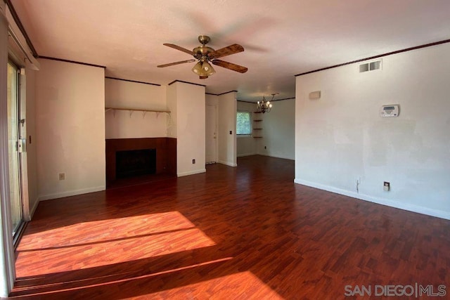 unfurnished living room with crown molding, ceiling fan with notable chandelier, and dark hardwood / wood-style floors