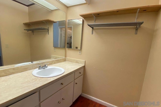 bathroom featuring vanity, a skylight, and wood-type flooring