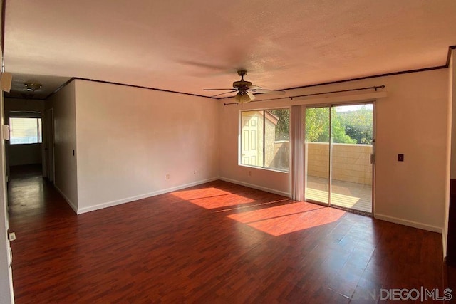 empty room with crown molding, dark hardwood / wood-style floors, and ceiling fan