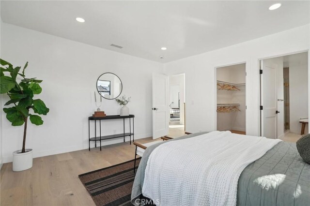 bedroom featuring a walk in closet and light wood-type flooring