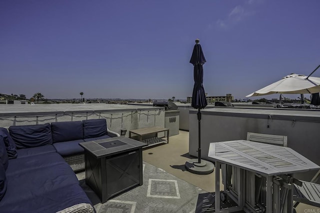 patio terrace at dusk featuring area for grilling and an outdoor living space with a fire pit