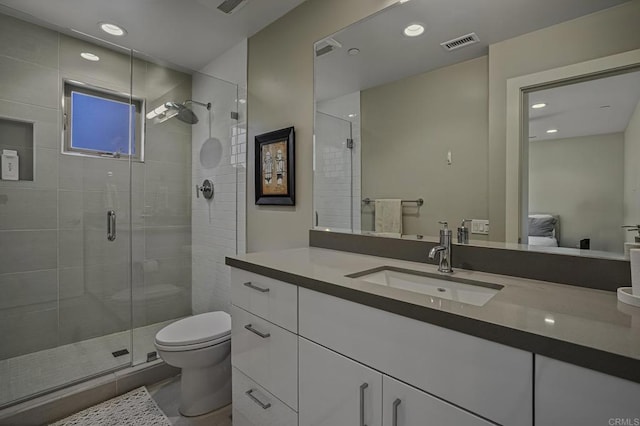 bathroom featuring vanity, toilet, and walk in shower