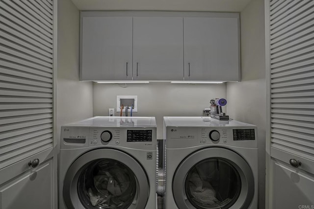 laundry area featuring cabinets and washer and clothes dryer