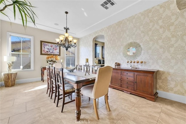 dining space with light tile patterned floors and a notable chandelier