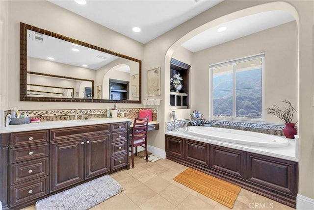 bathroom featuring a washtub, vanity, and tile patterned floors