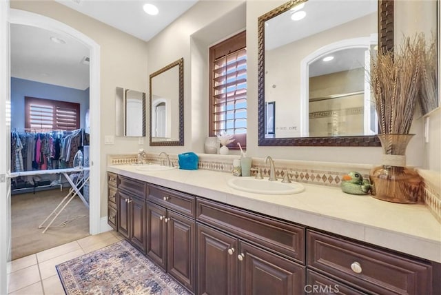 bathroom with tile patterned floors, vanity, and an enclosed shower