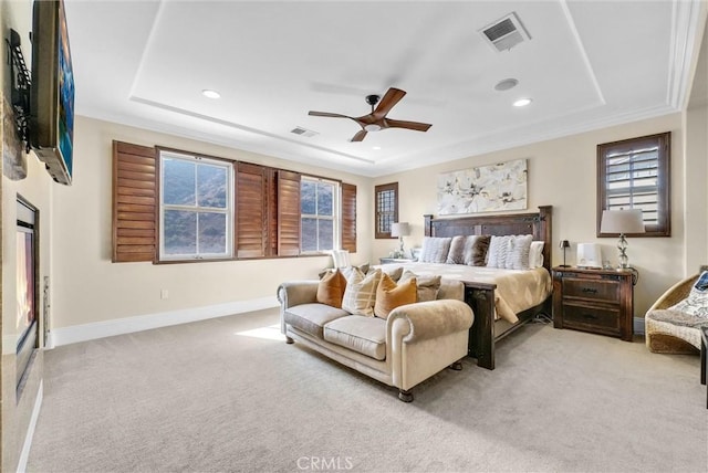 carpeted bedroom with ceiling fan and a tray ceiling