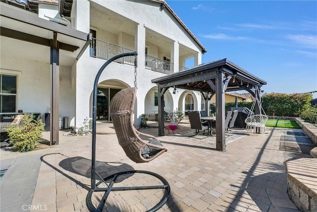 view of patio / terrace featuring a gazebo and a balcony