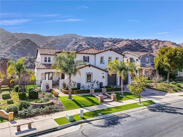 mediterranean / spanish house featuring a mountain view and a front yard