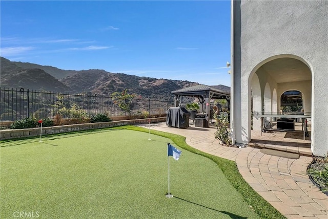 view of property's community featuring a gazebo, a mountain view, and a patio