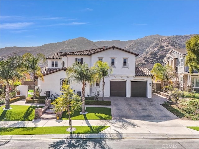 mediterranean / spanish-style house with a garage and a mountain view