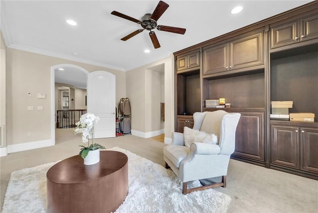 living area with crown molding and light colored carpet