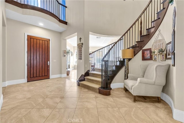 foyer featuring a towering ceiling and light tile patterned floors