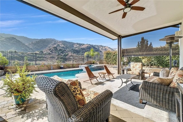 view of patio / terrace featuring a fenced in pool, ceiling fan, an outdoor living space, and a mountain view