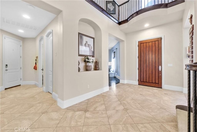 entryway featuring light tile patterned flooring and a high ceiling