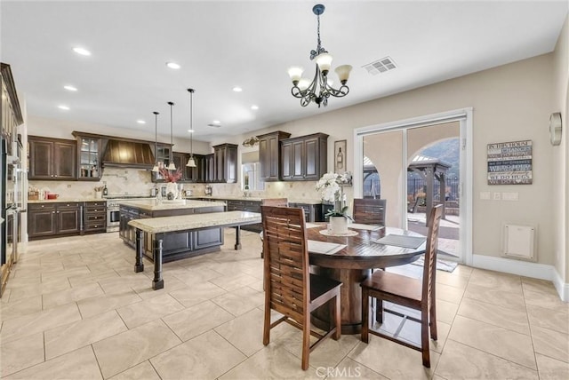 tiled dining room with a chandelier