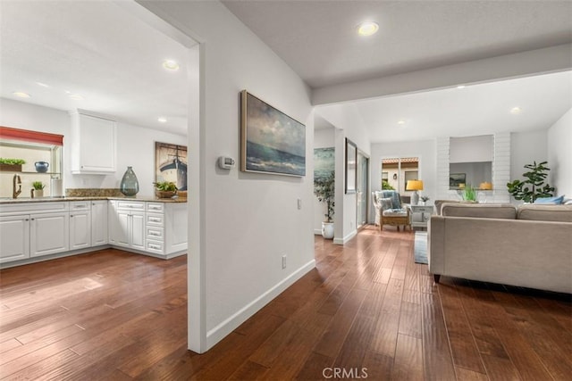 living room with dark hardwood / wood-style floors and sink