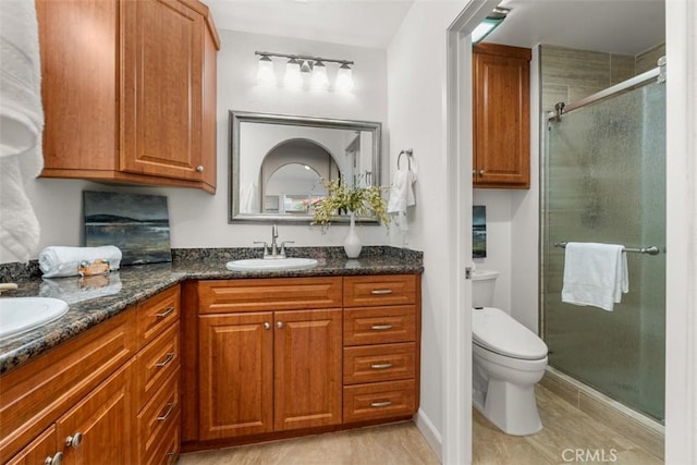 bathroom featuring walk in shower, vanity, and toilet